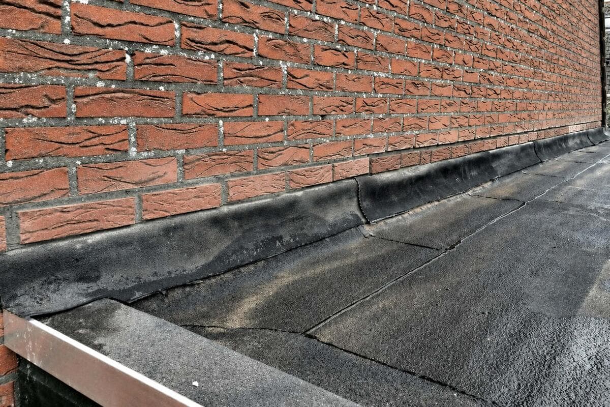 Loodvervanger als waterkering tussen bakstenen gevel en plat EPDM-dak