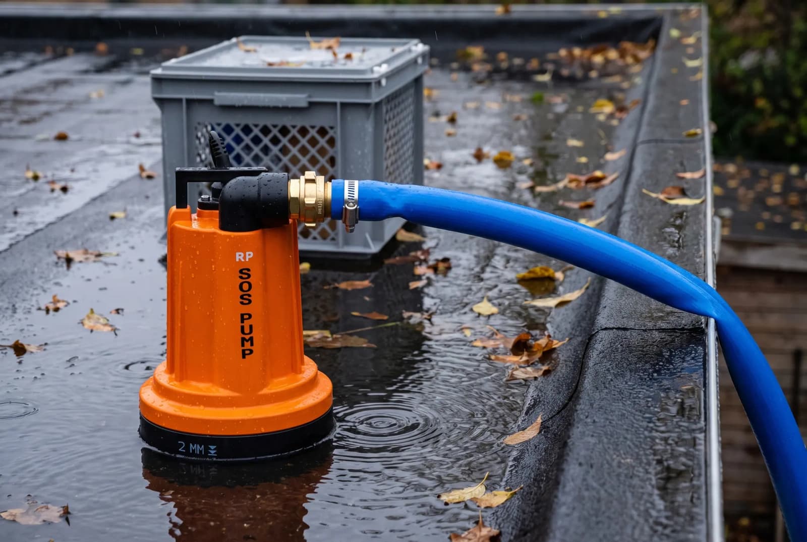 SOS PUMP dompelpomp pompt plaswater van een plat dak met herfstbladeren